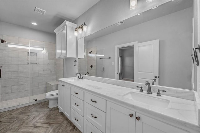 bathroom with vanity, a shower with shower door, and toilet