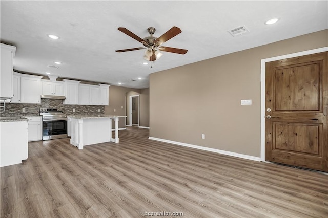 508 N O Neal St, Caldwell, TX 77836 - kitchen featuring a center island, stainless steel stove, light hardwood / wood-style flooring, ceiling fan, and white cabinetry