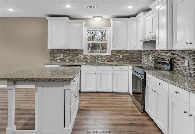 508 N O Neal St, Caldwell, TX 77836 - kitchen with white cabinetry, sink, dark stone counters, stainless steel range with electric cooktop, and hardwood / wood-style flooring