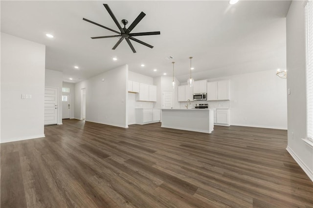 unfurnished living room featuring ceiling fan and dark wood-type flooring