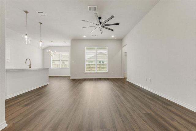 unfurnished living room featuring ceiling fan with notable chandelier, dark hardwood / wood-style floors, and sink