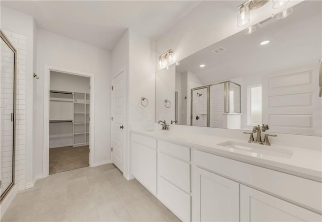 bathroom with tile patterned flooring, vanity, and a shower with shower door