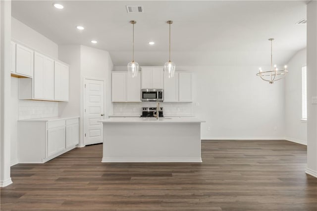 kitchen with stainless steel appliances, dark wood-type flooring, a center island with sink, white cabinetry, and hanging light fixtures