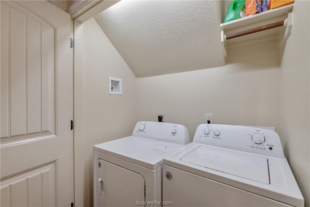 clothes washing area with washer and clothes dryer and a textured ceiling