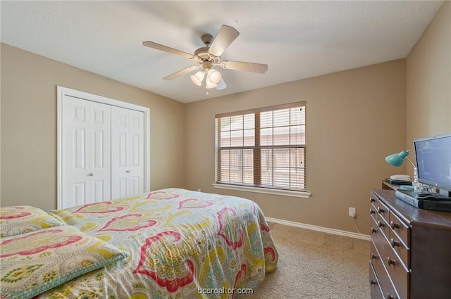 carpeted bedroom with ceiling fan and a closet