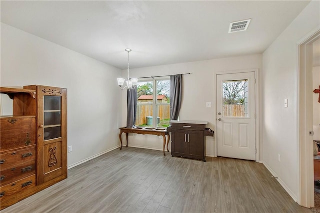 foyer with a notable chandelier and light hardwood / wood-style floors