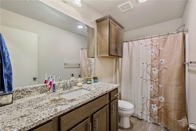 bathroom with vanity, hardwood / wood-style flooring, and toilet