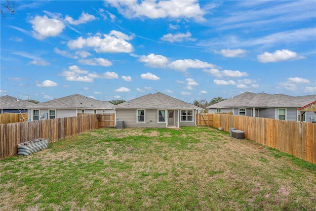 rear view of property featuring a yard and central AC