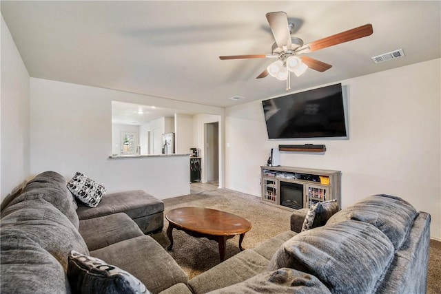 carpeted living room with ceiling fan