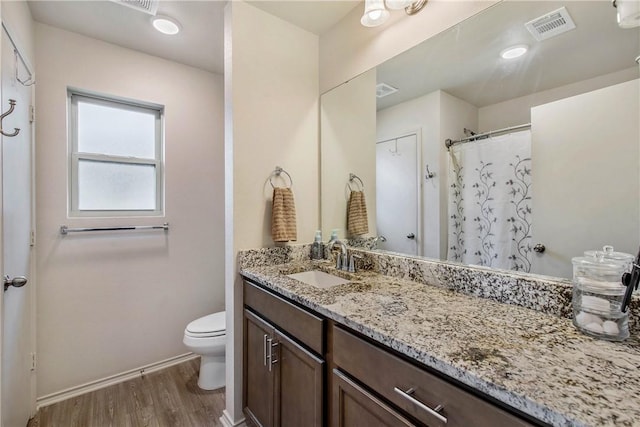 bathroom with vanity, hardwood / wood-style flooring, and toilet