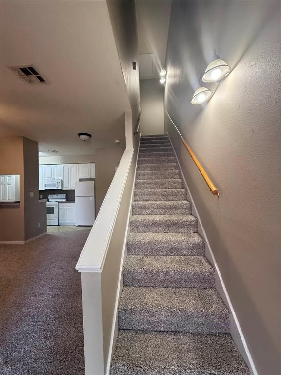 1305 W Villa Maria Rd Unit A-105, Bryan, TX 77801 - staircase featuring baseboards and carpet floors