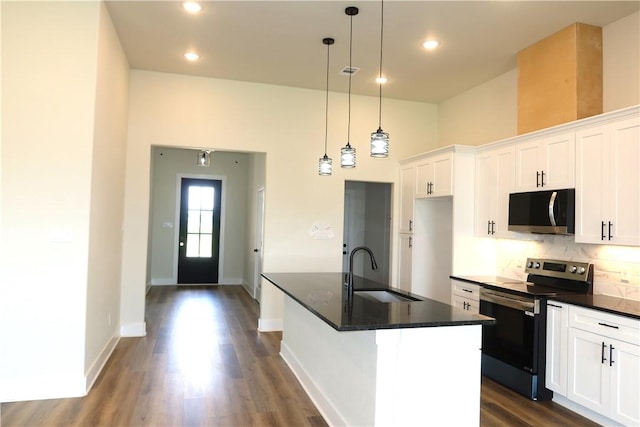 1977 Cambria Dr, Bryan, TX 77807 - kitchen with appliances with stainless steel finishes, dark wood-style floors, decorative backsplash, white cabinetry, and recessed lighting