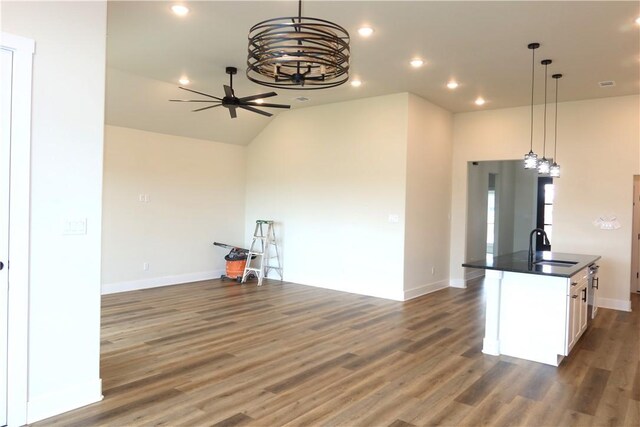 1977 Cambria Dr, Bryan, TX 77807 - kitchen with open floor plan, dark countertops, wood finished floors, white cabinets, and a ceiling fan