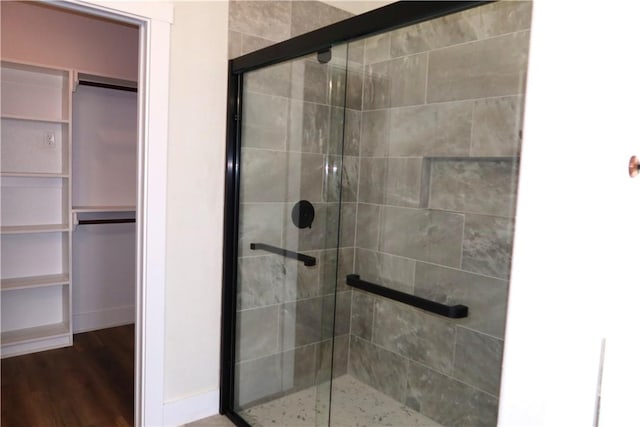 1977 Cambria Dr, Bryan, TX 77807 - full bathroom featuring a stall shower, a spacious closet, and wood finished floors