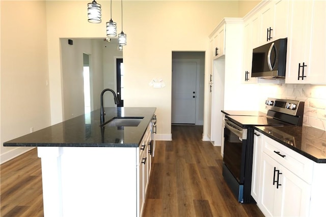 1977 Cambria Dr, Bryan, TX 77807 - kitchen featuring stainless steel appliances, a kitchen island with sink, dark wood-type flooring, white cabinets, and a high ceiling