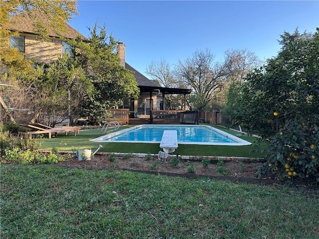 view of pool featuring a diving board and a lawn