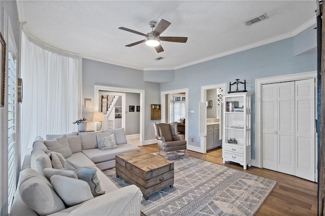 living room with hardwood / wood-style flooring, ceiling fan, and ornamental molding