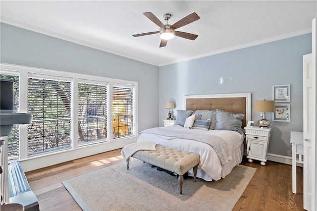 bedroom featuring hardwood / wood-style floors, ceiling fan, and ornamental molding