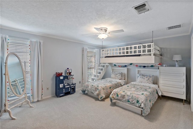 carpeted bedroom with ceiling fan, a textured ceiling, and ornamental molding