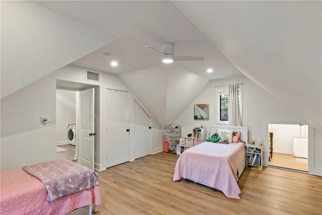 bedroom featuring vaulted ceiling, washer / clothes dryer, light hardwood / wood-style flooring, and ceiling fan