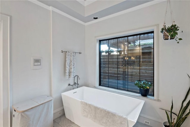 bathroom featuring crown molding and a tub