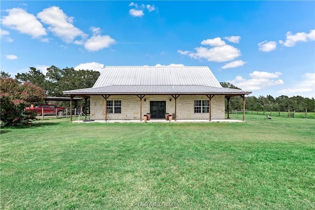 back of property featuring covered porch and a yard