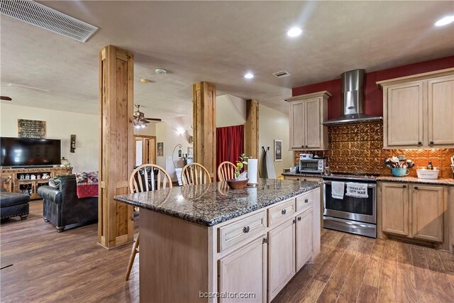 kitchen featuring dark hardwood / wood-style flooring, stainless steel range with electric stovetop, wall chimney exhaust hood, and dark stone countertops