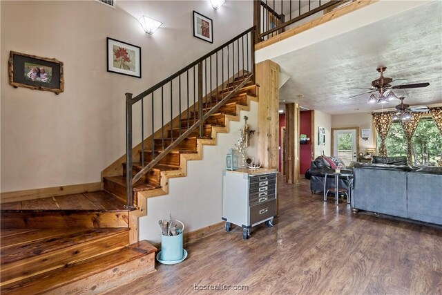 stairs featuring ceiling fan and wood-type flooring