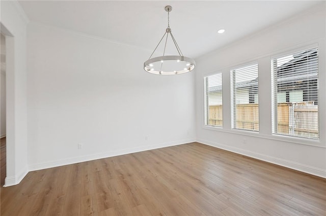 unfurnished room featuring light hardwood / wood-style floors, ornamental molding, and a chandelier