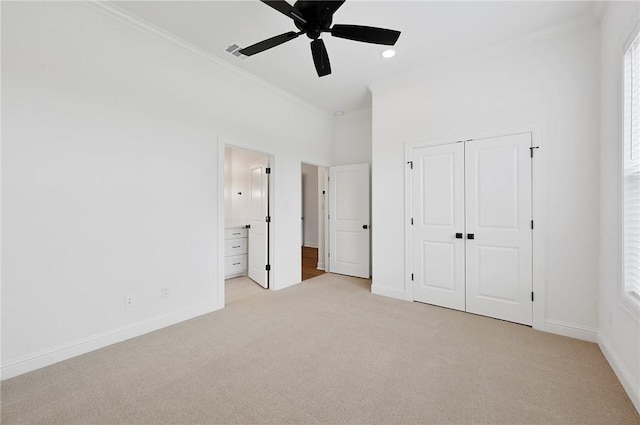 unfurnished bedroom featuring ensuite bath, ceiling fan, a closet, and light carpet