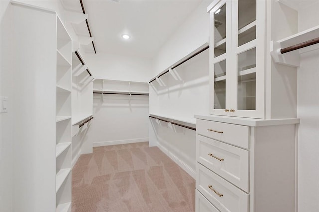 walk in closet featuring light colored carpet