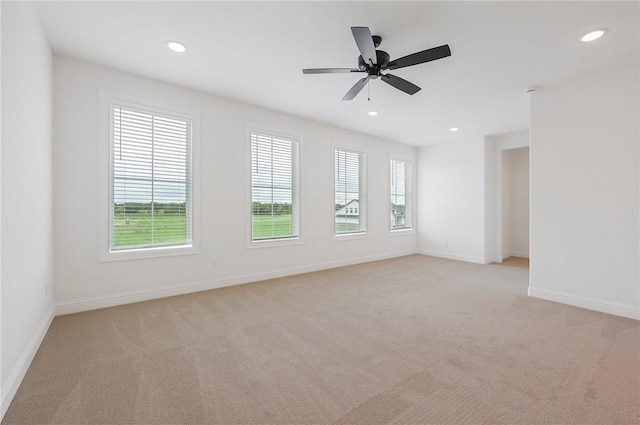 unfurnished room featuring light colored carpet and ceiling fan