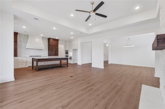 living room with ceiling fan and light hardwood / wood-style flooring