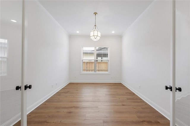 unfurnished dining area with wood-type flooring and ornamental molding