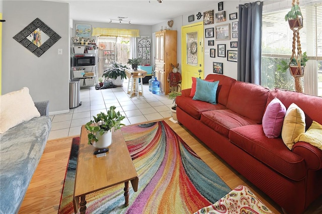 living area with rail lighting and light tile patterned floors