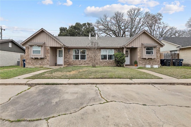 ranch-style house with roof with shingles, brick siding, board and batten siding, and a front yard