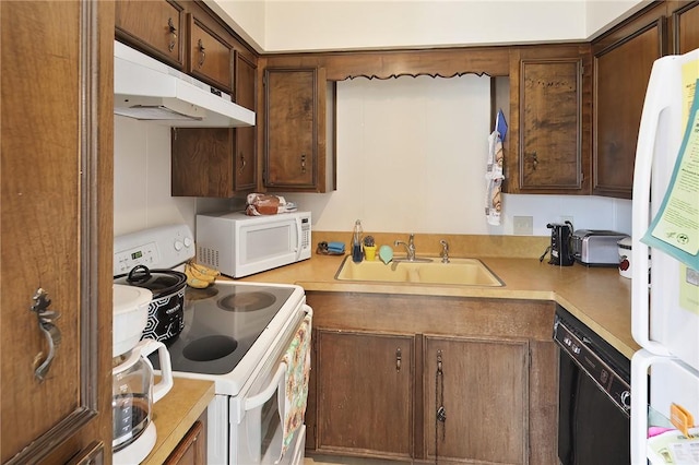 kitchen featuring white appliances, light countertops, and a sink