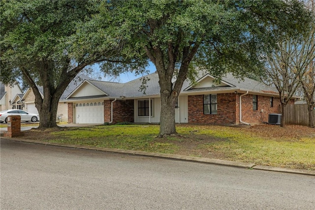 view of front of home featuring a garage, a front lawn, and central air condition unit