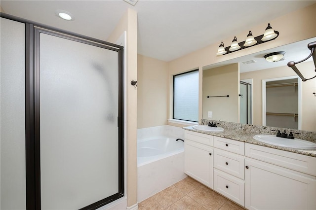 full bath featuring a garden tub, double vanity, a sink, a shower stall, and tile patterned flooring