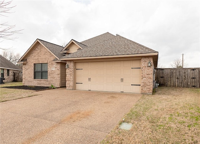 view of front of house featuring a shingled roof, brick siding, fence, and an attached garage