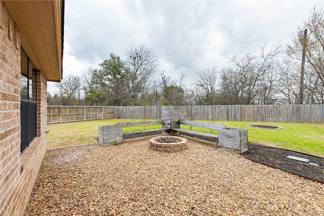 view of yard with a fenced backyard and a fire pit