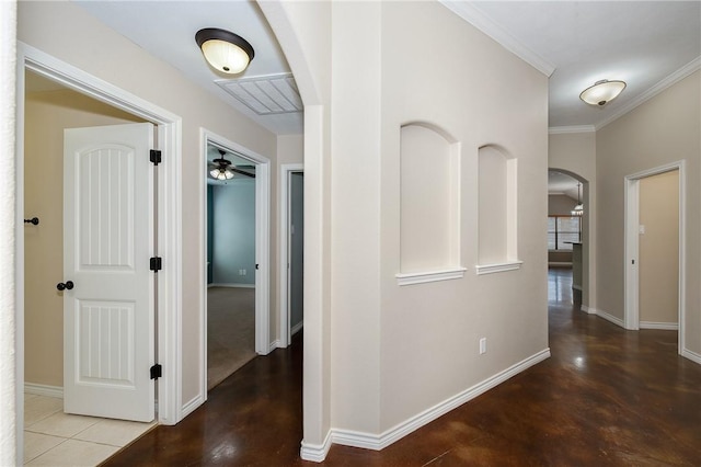 corridor with arched walkways, crown molding, and baseboards