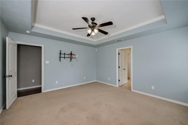 unfurnished bedroom featuring baseboards, visible vents, and a tray ceiling