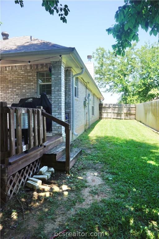 view of home's exterior with a wooden deck and a yard