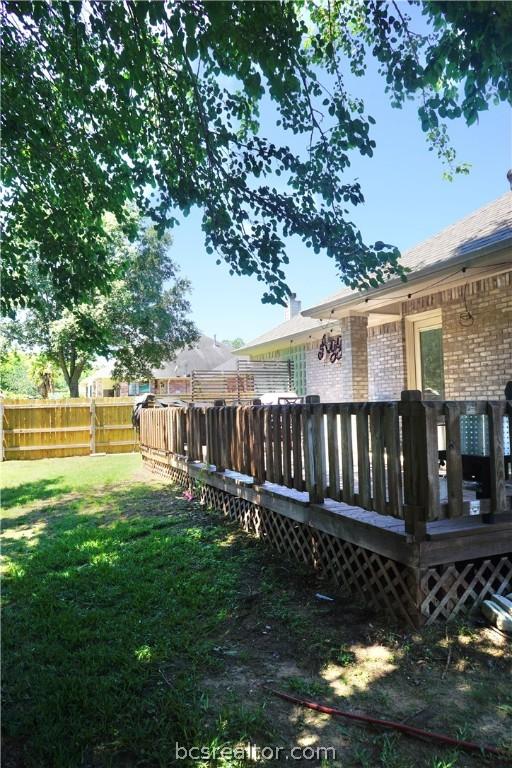 rear view of property with a lawn and a wooden deck