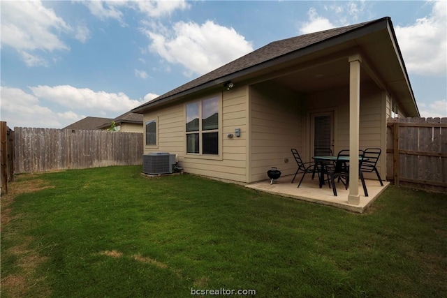 back of house with a lawn, central air condition unit, and a patio