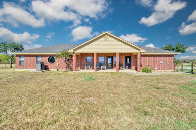 back of property with central AC and a lawn