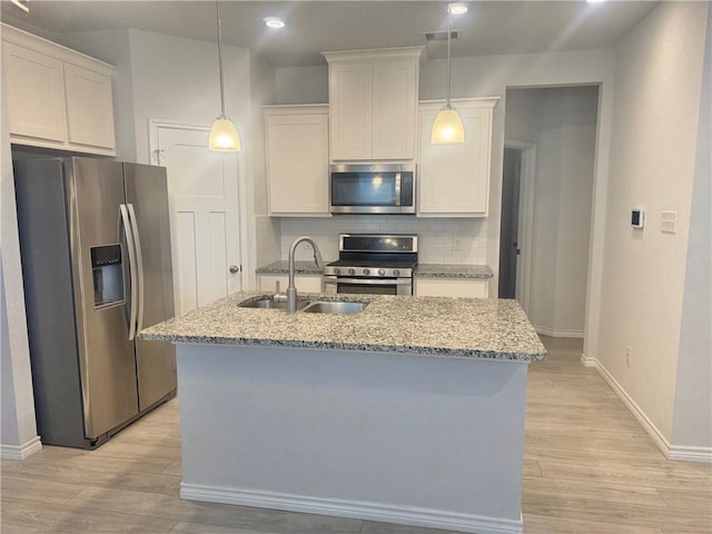1074 Toledo Bend Dr, College Station, TX 77845 - kitchen featuring stainless steel appliances, light wood-style floors, light stone countertops, white cabinetry, and recessed lighting