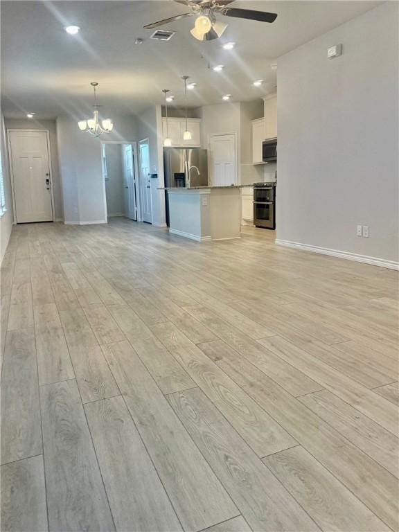 1074 Toledo Bend Dr, College Station, TX 77845 - unfurnished living room with a chandelier, a ceiling fan, and light wood-type flooring