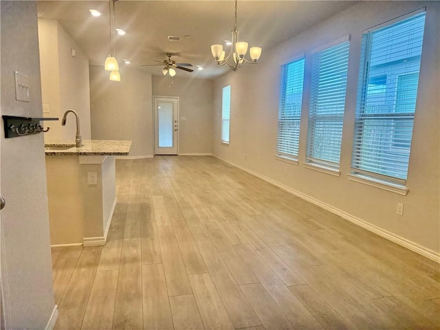 1074 Toledo Bend Dr, College Station, TX 77845 - kitchen featuring light wood-style flooring, light stone counters, ceiling fan, a chandelier, and decorative light fixtures